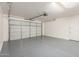 Well-lit garage featuring a clean epoxy floor and a functional overhead door system at 2765 E Gillcrest Rd, Gilbert, AZ 85298