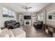 Spacious living room featuring a fireplace, a ceiling fan, and comfortable black leather seating at 2765 E Gillcrest Rd, Gilbert, AZ 85298
