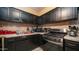 A kitchen featuring dark cabinets, stainless steel appliances, and tile backsplash at 3101 N 65Th Ave, Phoenix, AZ 85033