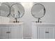 Close-up of a modern bathroom with dual vanities and elegant round mirrors at 3144 W Maya Way, Phoenix, AZ 85083