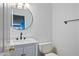 Charming powder room featuring a round mirror, marble countertop, and modern fixtures at 3144 W Maya Way, Phoenix, AZ 85083