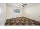 A bedroom features mixed color tiled flooring, a window, neutral colored walls, and a ceiling fan at 3144 W Maya Way, Phoenix, AZ 85083