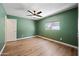 Cozy bedroom features wood-look floors, a ceiling fan, and a sunlit window at 3144 W Maya Way, Phoenix, AZ 85083