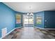 A blue walled dining room features a hanging chandelier, large windows, and mixed color tiled flooring at 3144 W Maya Way, Phoenix, AZ 85083