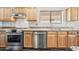 Modern kitchen featuring stainless steel appliances, granite countertops, and light wood cabinets at 3144 W Maya Way, Phoenix, AZ 85083