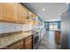 Bright kitchen features stainless steel appliances, wooden cabinets, granite countertops, and mixed color tiled flooring at 3144 W Maya Way, Phoenix, AZ 85083