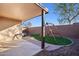 Backyard with a covered patio, desert landscaping, and a swing set at 325 W Angus Rd, San Tan Valley, AZ 85143