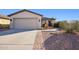 Charming single-story home featuring a desert landscape, brick walkway and two car garage at 325 W Angus Rd, San Tan Valley, AZ 85143