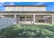Expansive backyard with manicured synthetic lawn, covered patio and large windows offering natural light at 3419 E Rosa Ln, Gilbert, AZ 85297