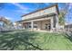 Spacious backyard featuring artificial turf, a covered patio, and a fenced-in area perfect for entertaining at 3419 E Rosa Ln, Gilbert, AZ 85297