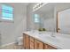 This bathroom features wood cabinets, dual sinks, a framed mirror, and natural light at 3419 E Rosa Ln, Gilbert, AZ 85297