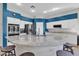 Open-concept kitchen features stainless steel appliances, granite countertops, an island with barstool seating and blue accent wall at 3419 E Rosa Ln, Gilbert, AZ 85297