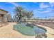Backyard pool featuring rock accents, lounge furniture, and surrounded by desert landscaping under a bright blue sky at 3419 E Rosa Ln, Gilbert, AZ 85297