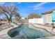 View of the backyard pool with rock accents and partial surrounding fence, under a beautiful blue sky at 3419 E Rosa Ln, Gilbert, AZ 85297
