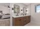 Bathroom featuring double sink vanity and tile backsplash adjacent to the main bedroom at 3939 E Sahuaro Dr, Phoenix, AZ 85028