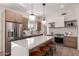 Bright kitchen featuring quartz island with seating, stainless appliances, and stylish light fixtures at 3939 E Sahuaro Dr, Phoenix, AZ 85028
