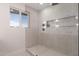 Elegant glass-enclosed shower with sleek fixtures and decorative niche at 3939 E Sahuaro Dr, Phoenix, AZ 85028