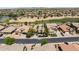 Overhead view of charming homes with well-maintained lawns near a golf course and green spaces at 42476 W Chisholm Dr, Maricopa, AZ 85138
