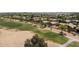Expansive aerial shot of a vibrant community with lush green golf course and well-maintained residential homes at 42476 W Chisholm Dr, Maricopa, AZ 85138