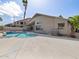 Backyard pool with palm trees, concrete patio, view of house, and view of surrounding houses at 42476 W Chisholm Dr, Maricopa, AZ 85138