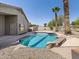An expansive view of the pristine in-ground pool, surrounded by landscaping and the home's facade at 42476 W Chisholm Dr, Maricopa, AZ 85138