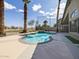 The kidney shaped pool with palm trees and view of the golf course in the background at 42476 W Chisholm Dr, Maricopa, AZ 85138