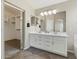 Bathroom featuring a large vanity with double sinks, a large mirror, and a walk-in closet at 42476 W Chisholm Dr, Maricopa, AZ 85138