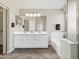 Spacious bathroom with double sinks, large mirrors, and a separate shower and soaking tub at 42476 W Chisholm Dr, Maricopa, AZ 85138