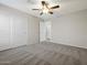 This bedroom has neutral walls, gray carpet, and a ceiling fan for added comfort at 42476 W Chisholm Dr, Maricopa, AZ 85138