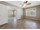 Secondary bedroom boasts tile flooring, neutral walls, white trim, plantation shutters, and a ceiling fan at 42476 W Chisholm Dr, Maricopa, AZ 85138