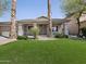 Beautifully landscaped front yard with green grass and desert plants at 42476 W Chisholm Dr, Maricopa, AZ 85138