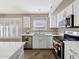 Bright kitchen featuring white cabinets, stainless steel appliances, and tile floors at 42476 W Chisholm Dr, Maricopa, AZ 85138