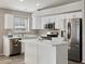 Well-equipped kitchen with white cabinets, stainless steel appliances, and center island at 42476 W Chisholm Dr, Maricopa, AZ 85138