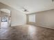 Open living room features tile flooring, neutral walls, a ceiling fan, and a view of the outdoor pool area at 42476 W Chisholm Dr, Maricopa, AZ 85138