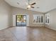 Open living room with vaulted ceiling, tile floor, and sliding glass doors to the pool at 42476 W Chisholm Dr, Maricopa, AZ 85138