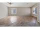 Bright living room boasts tile flooring, white trim, neutral walls, and two windows with plantation shutters at 42476 W Chisholm Dr, Maricopa, AZ 85138