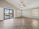 Living room features tile floor, open patio access, a ceiling fan, and white window shutters at 42476 W Chisholm Dr, Maricopa, AZ 85138