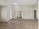 Open-concept living room with tile floors, neutral walls, white trim, and a view into another room at 42476 W Chisholm Dr, Maricopa, AZ 85138