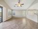 Living room features tile floors, open patio access, a ceiling fan, and white window shutters at 42476 W Chisholm Dr, Maricopa, AZ 85138
