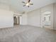 The main bedroom features an en-suite bathroom and neutral walls and gray carpet at 42476 W Chisholm Dr, Maricopa, AZ 85138