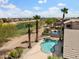 Relaxing backyard pool with patio area, palm trees, and picturesque views of the nearby golf course at 42476 W Chisholm Dr, Maricopa, AZ 85138