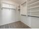 Walk-in closet includes carpeted floor, white walls, and shelves with racks to hang clothes at 42476 W Chisholm Dr, Maricopa, AZ 85138