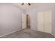 This carpeted bedroom has a ceiling fan and a closet with sliding doors at 44215 W Granite Dr, Maricopa, AZ 85139