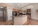 A kitchen is shown with stainless steel appliances, wood cabinets and a breakfast bar at 44215 W Granite Dr, Maricopa, AZ 85139