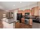 The kitchen features stainless steel appliances, wood cabinets and a view to living room at 44215 W Granite Dr, Maricopa, AZ 85139