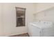 Bright laundry room featuring a washing machine, dryer, and shelving at 44215 W Granite Dr, Maricopa, AZ 85139