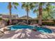 Outdoor pool surrounded by rocks, palm trees, and desert landscaping at 44215 W Granite Dr, Maricopa, AZ 85139