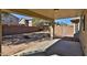 Backyard with covered patio, a desert landscape, block wall, and a built-in firepit at 44917 W Zion Rd, Maricopa, AZ 85139