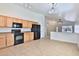 Well-lit kitchen with wood cabinets, black appliances, tile floors, and an open layout at 44917 W Zion Rd, Maricopa, AZ 85139