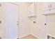 Bright laundry area with overhead cabinets, tile floor, and easy access to the outdoors through a secure door at 44917 W Zion Rd, Maricopa, AZ 85139